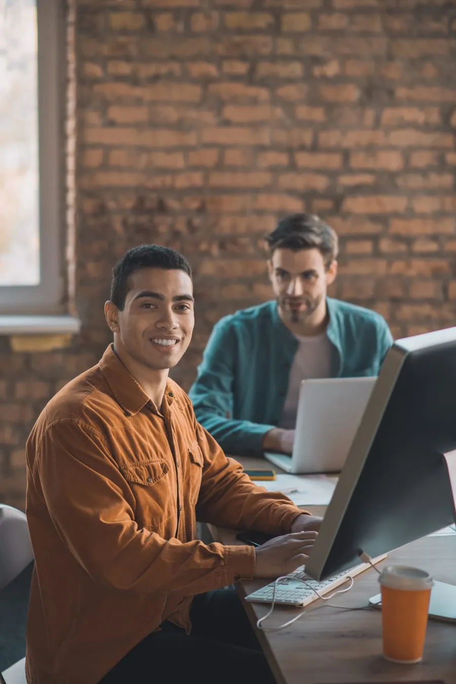 Two engineers working side by side at a desk